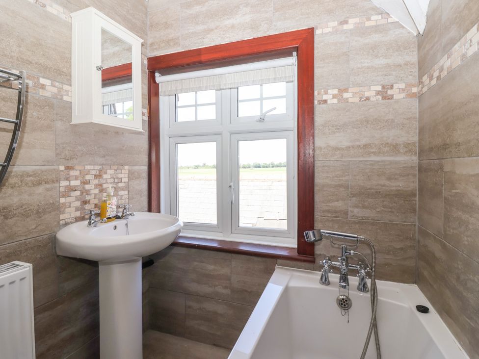A bathroom with a bathtub and sink at The Old Post Office 