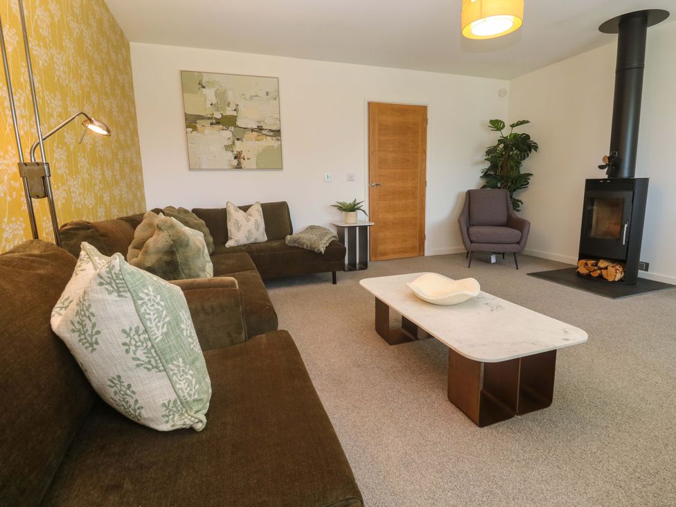 A living room with a sofa, coffee table, and fireplace at Agan Paradhis in Quintrell Downs
