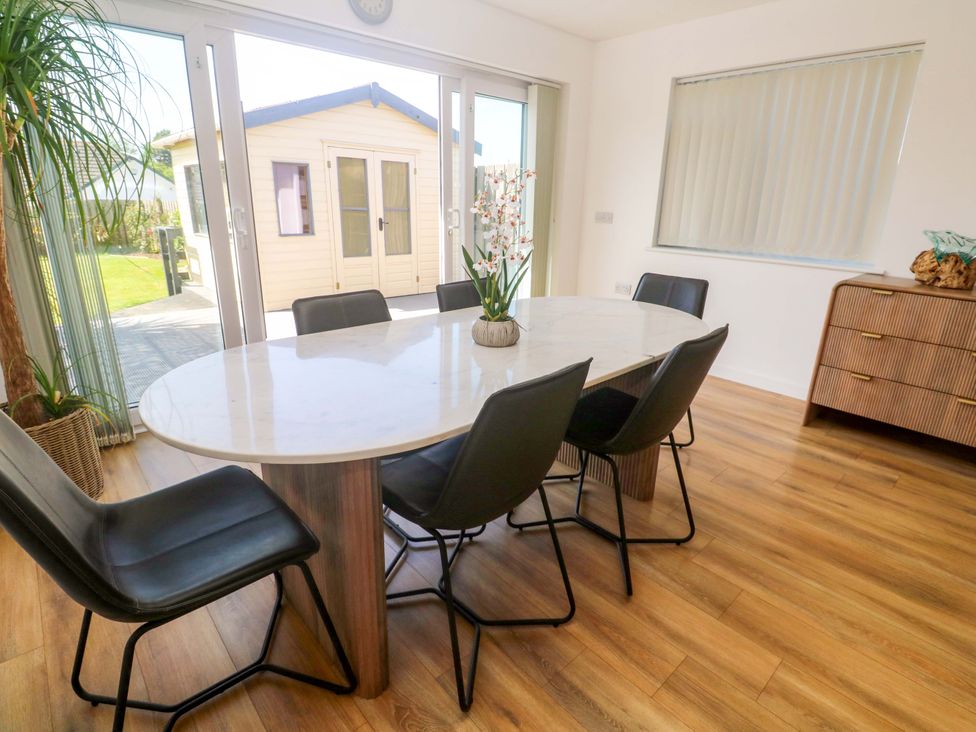 A dining room with a table and chairs at Agan Paradhis in Quintrell Downs