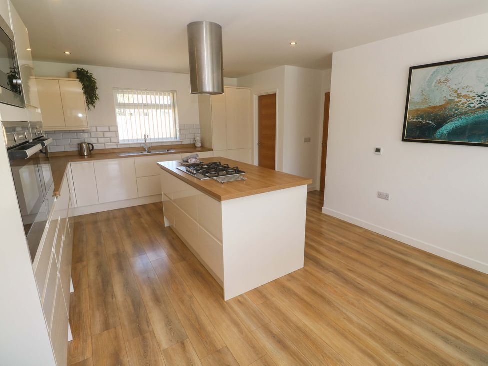 A kitchen with an island and gas stove at Agan Paradhis in Quintrell Downs