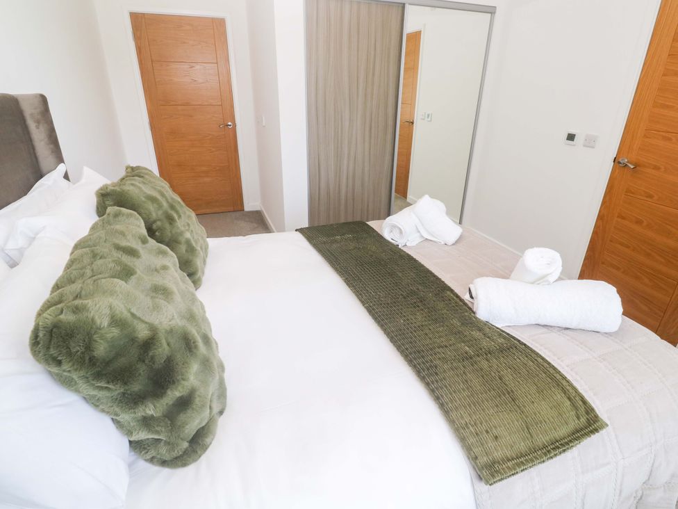 A bedroom with a bed and towels at Agan Paradhis in Quintrell Downs