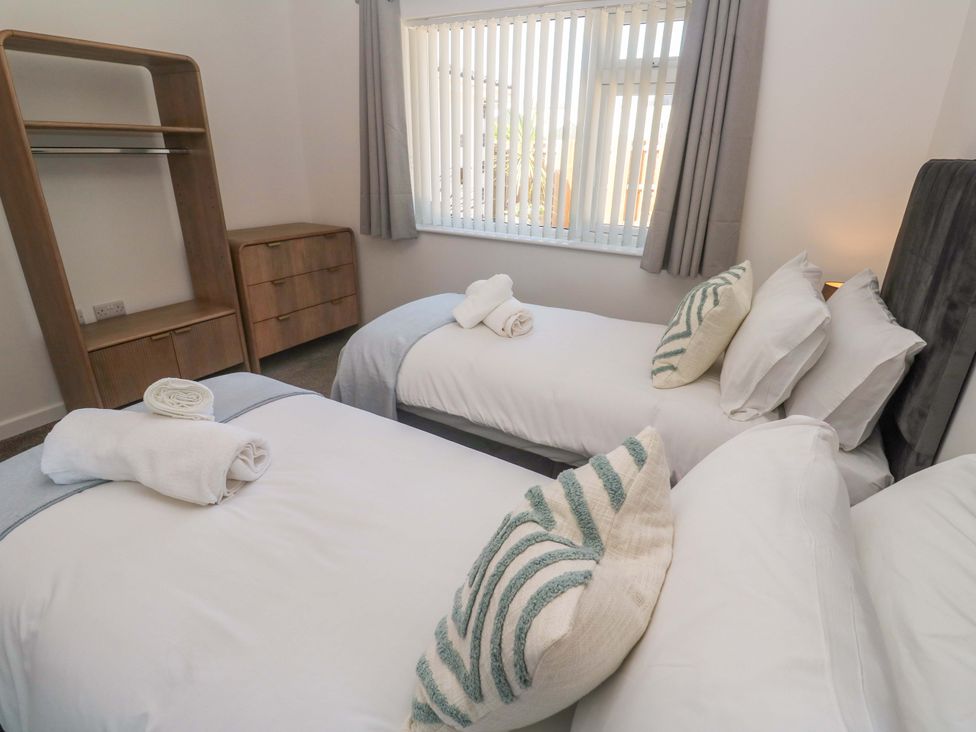 A bedroom with two beds and a dresser at Agan Paradhis in Quintrell Downs