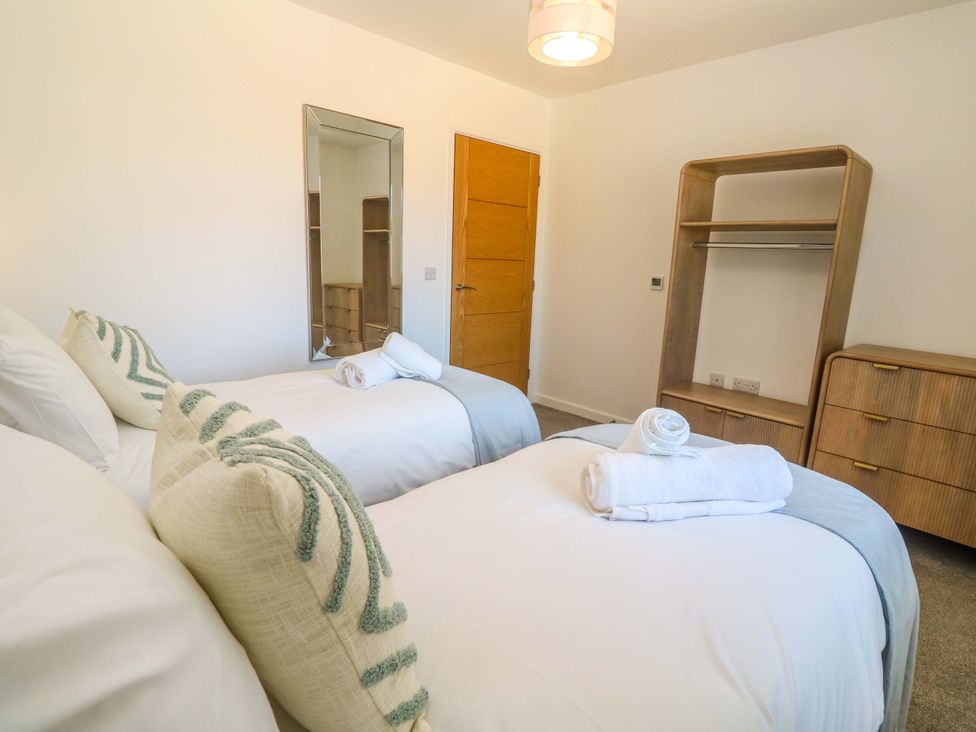 A bedroom with two beds and a wardrobe at Agan Paradhis in Quintrell Downs