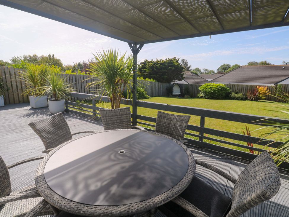 An outdoor seating area with a round table at Agan Paradhis in Quintrell Downs
