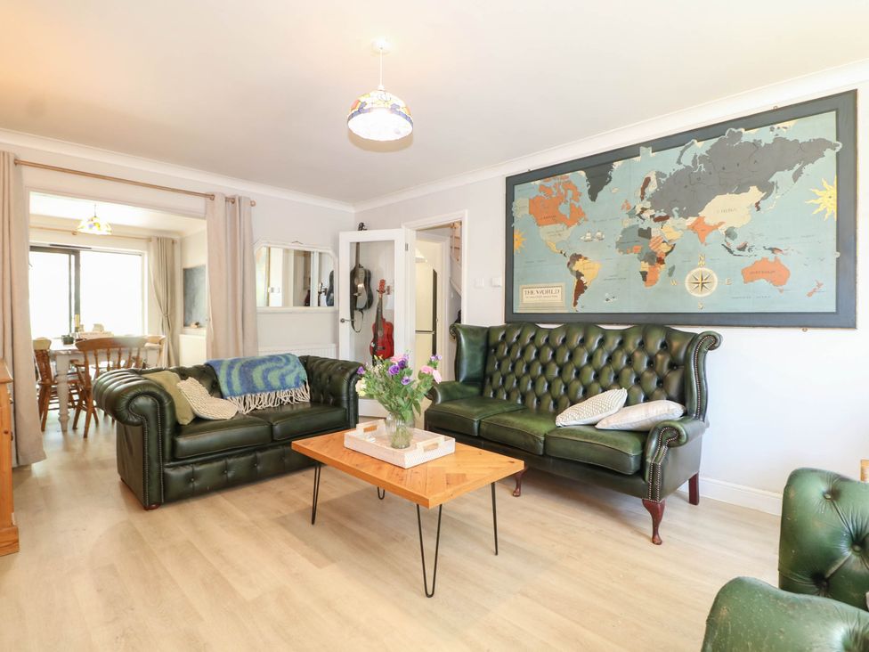 A living room with sofas and a map on the wall at Taliesin in Hailsham