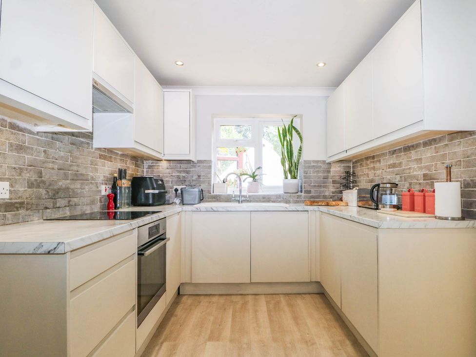 A kitchen with cabinets and appliances at Taliesin in Hailsham