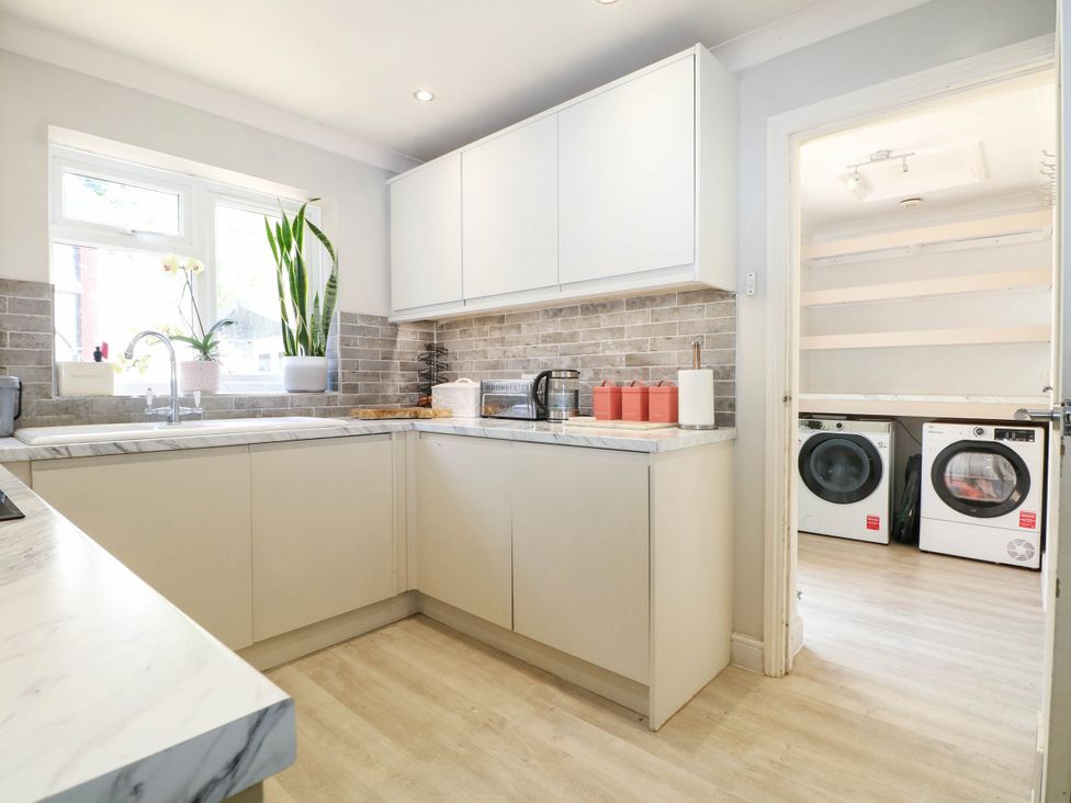 A kitchen with a sink and cupboard at Taliesin Hailsham