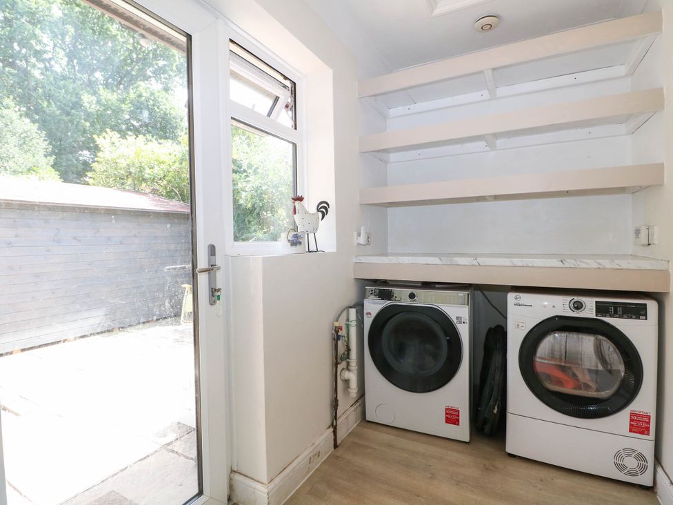 A utility room with washing machine and dryer at Taliesin in Hailsham