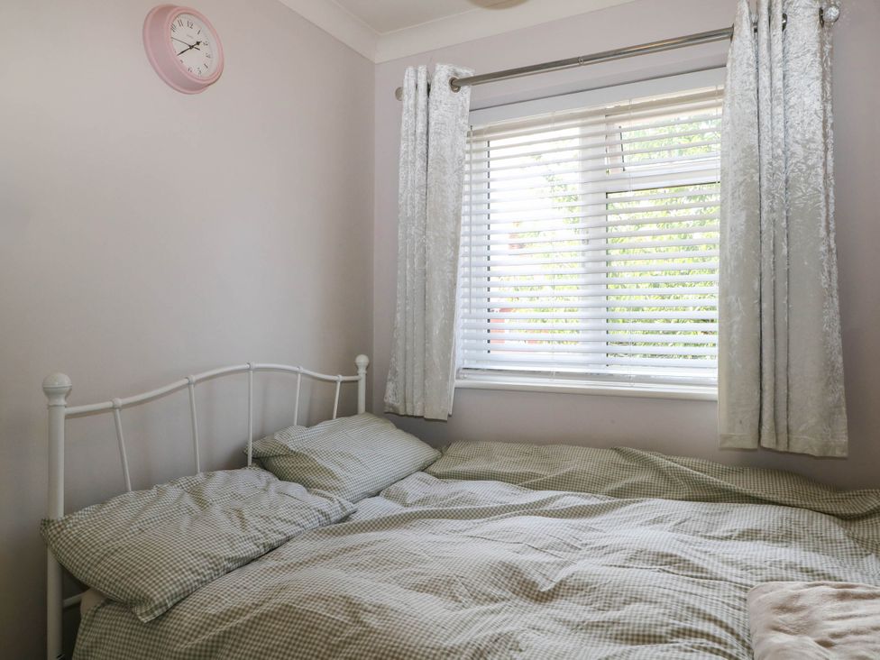 A bedroom with a bed and window at Taliesin in Hailsham