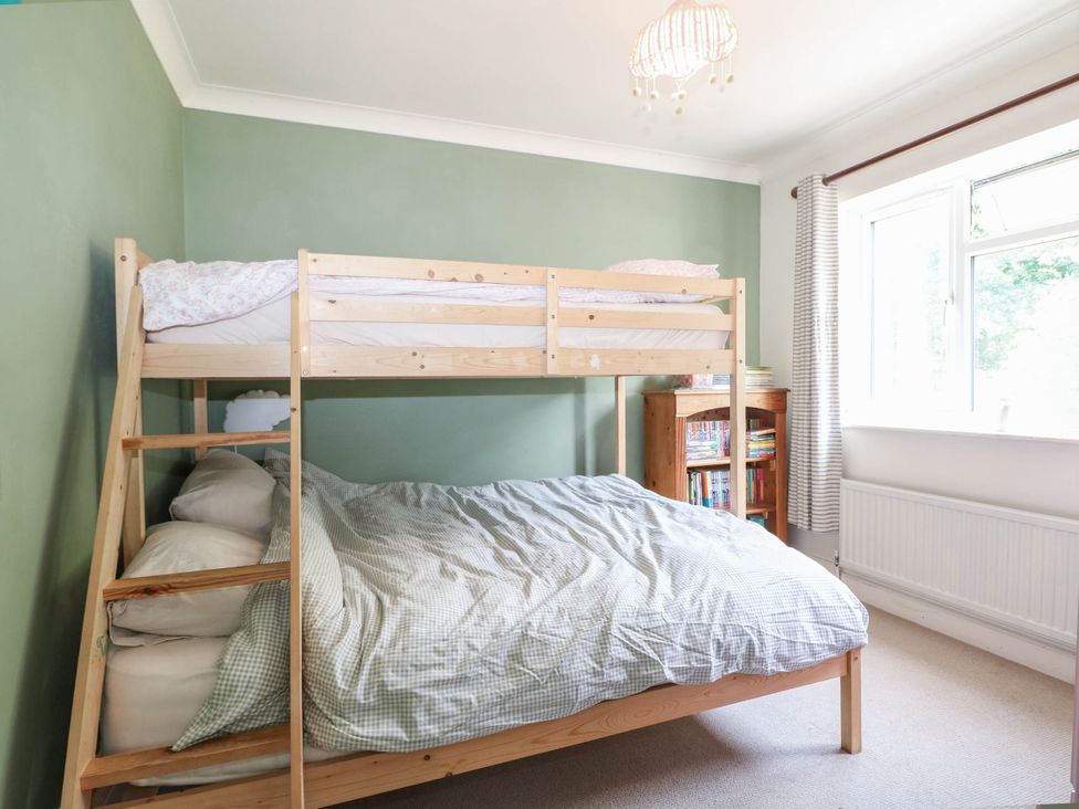 A bedroom with a bunk bed and shelves at Taliesin in Hailsham