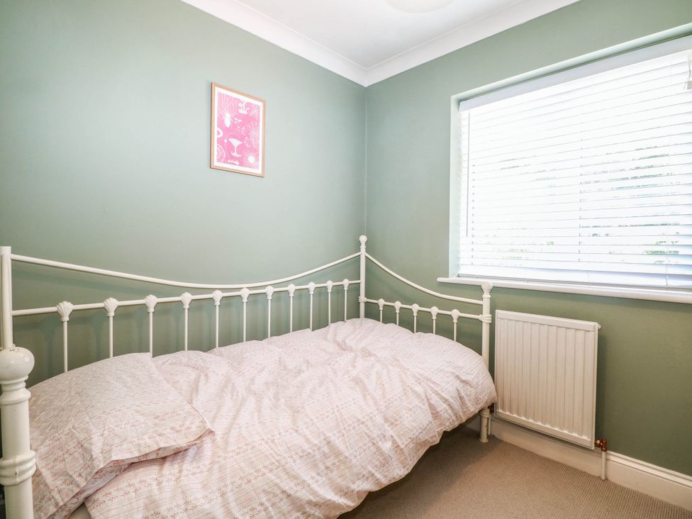 A bedroom with a single bed and a window at Taliesin in Hailsham