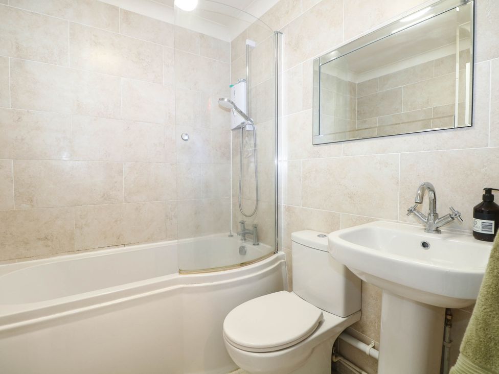 A bathroom with a bathtub, shower, toilet, and sink at Taliesin in Hailsham
