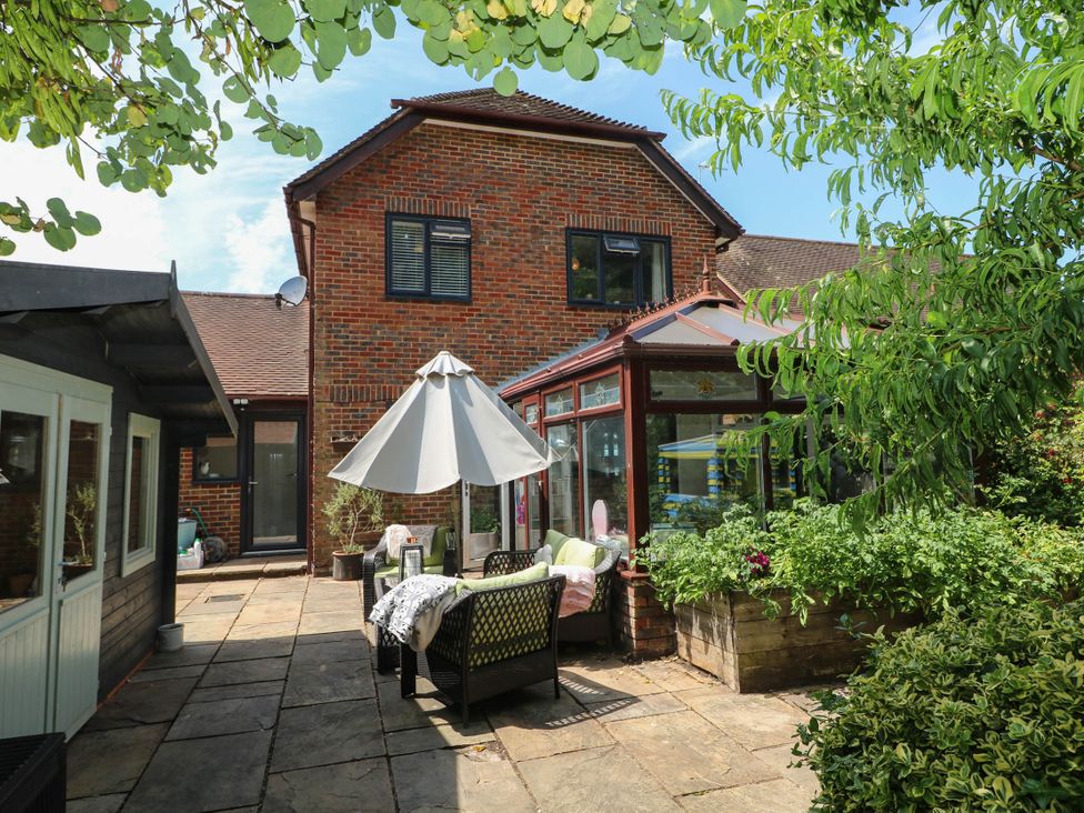An outdoor area with a patio and umbrella at Taliesin in Hailsham