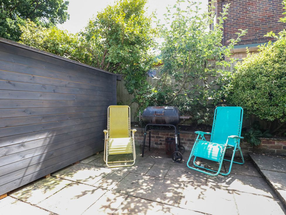 A garden with two chairs and a barbecue at Taliesin in Hailsham