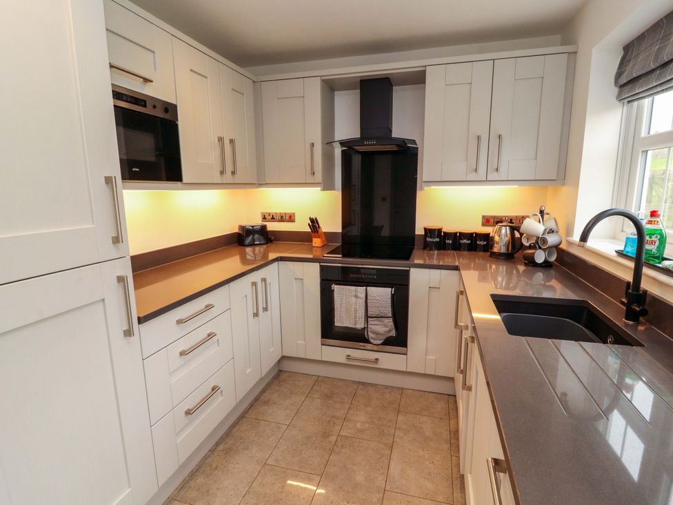 A kitchen with cabinets, oven, sink, and appliances at 11 The Forge Brampton