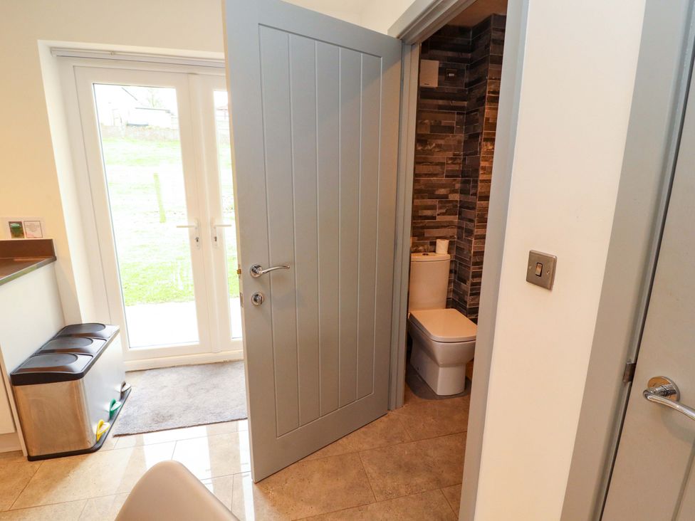A bathroom with a toilet and door leading to outside at 11 The Forge in Brampton