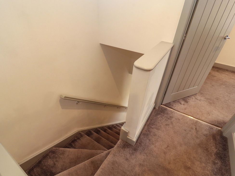 A staircase with a handrail leading to a door at 11 The Forge in Brampton