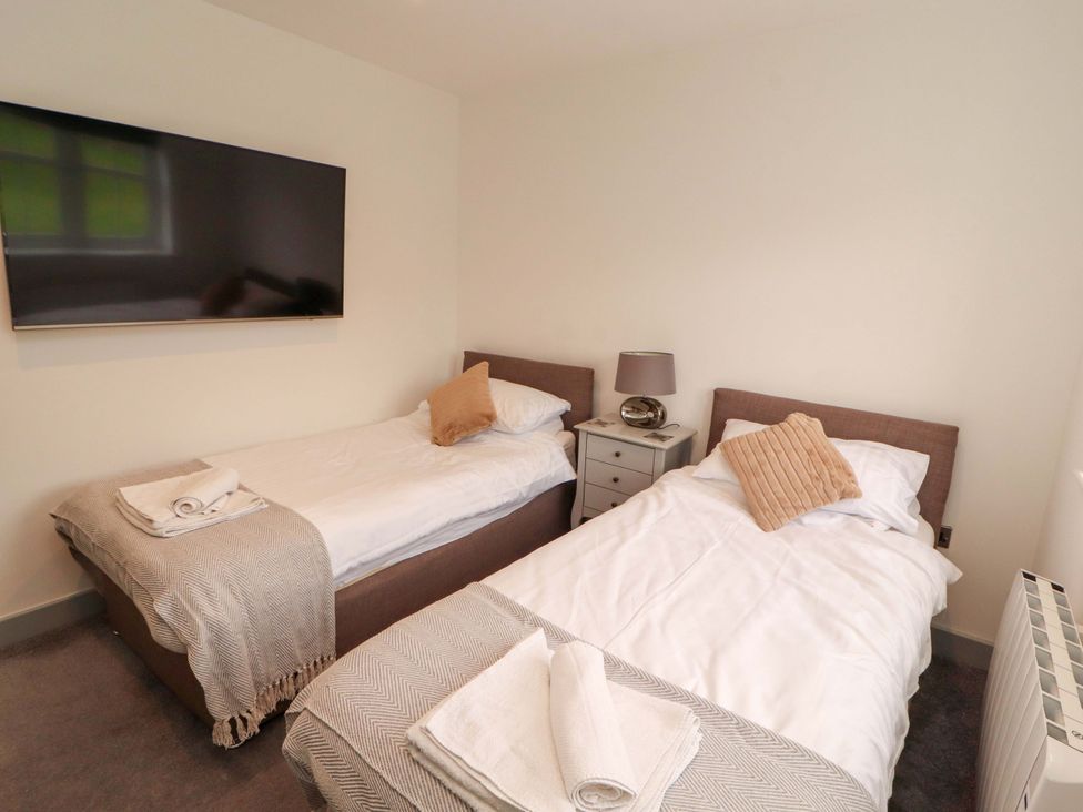 A bedroom with two single beds and a television at 11 The Forge in Brampton
