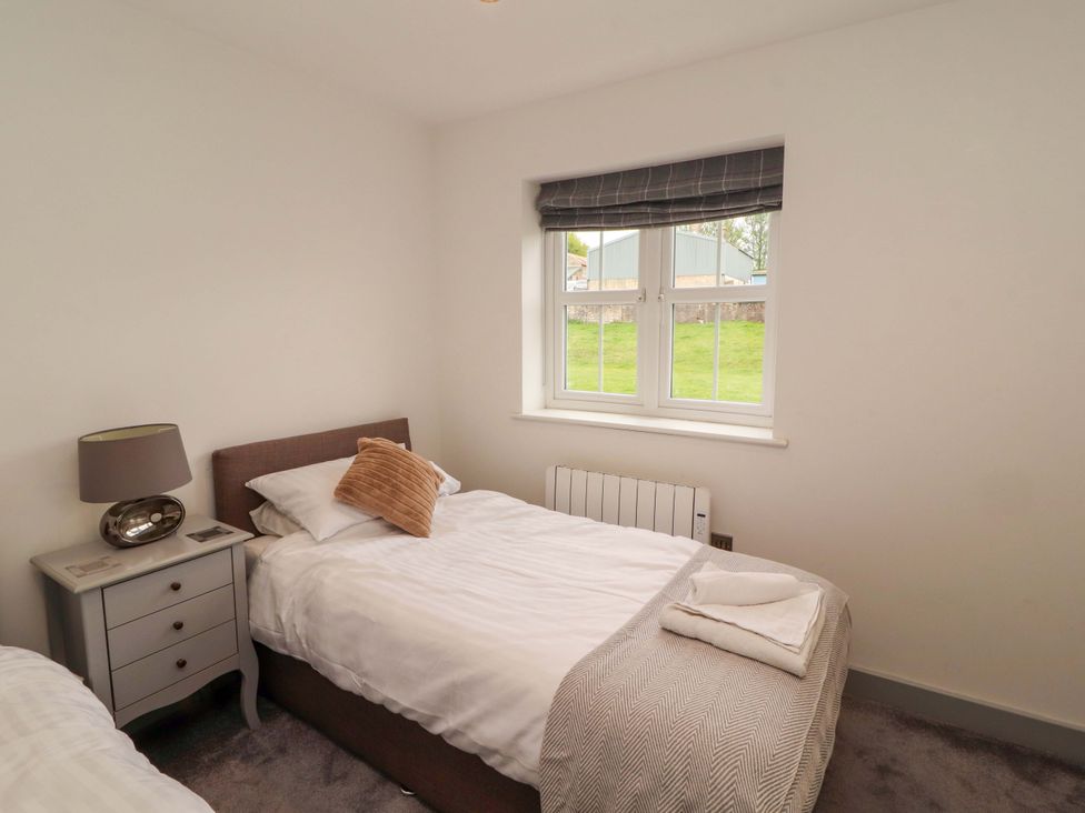 A bedroom with twin beds and a bedside table at 11 The Forge in Brampton