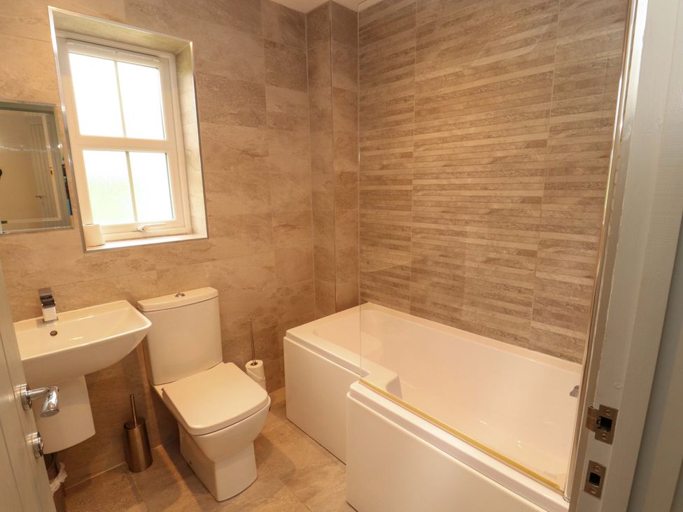 A bathroom with a toilet, sink, and bathtub at 11 The Forge in Brampton