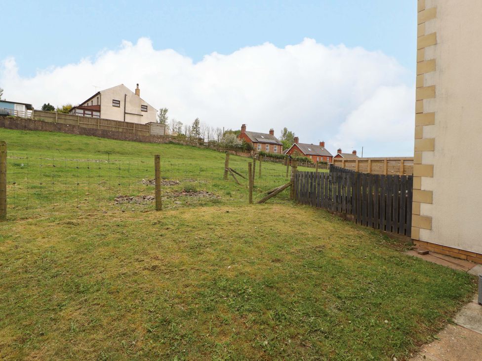 A garden with grass and a fence at 11 The Forge in Brampton