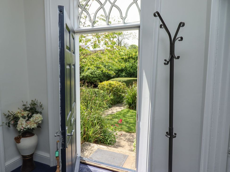 An entrance with a door open to a garden at Reighton House in Filey