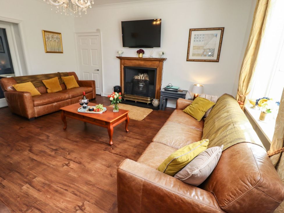 A living room with sofas and a coffee table at Reighton House in Filey
