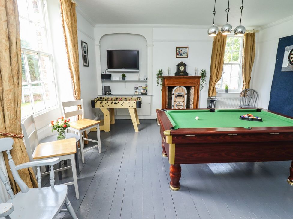 A game room with a pool table and foosball table at Reighton House in Filey