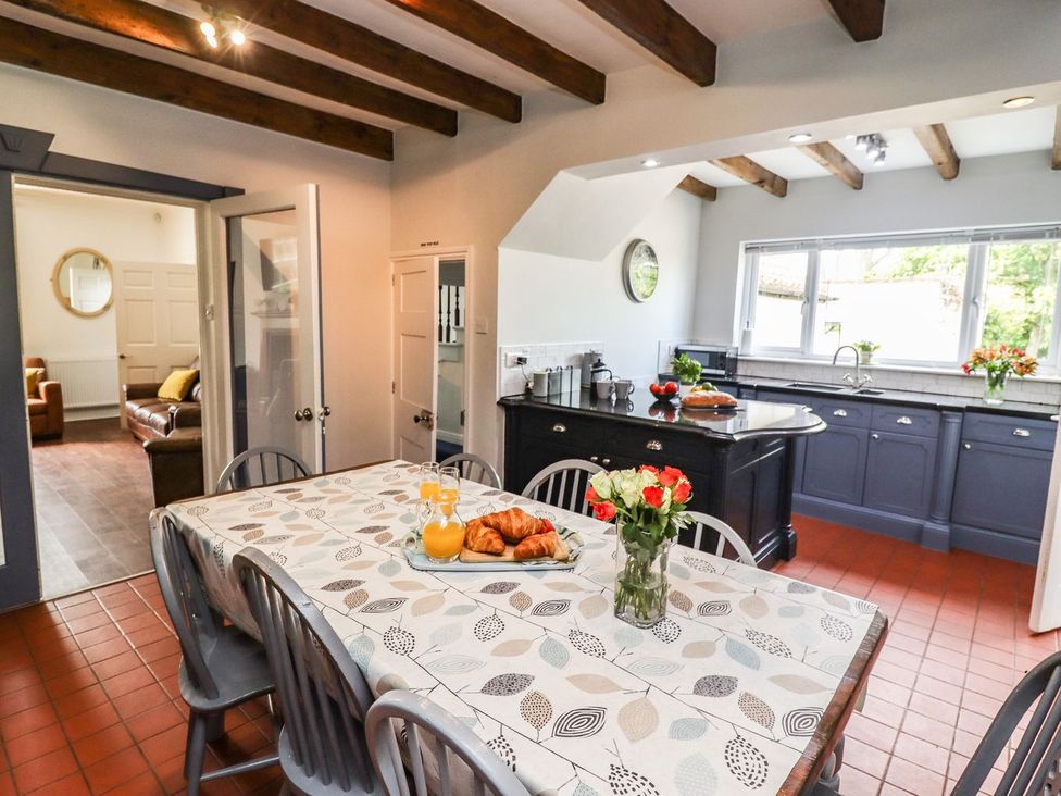 A kitchen with a dining table and orange juice at Reighton House in Filey