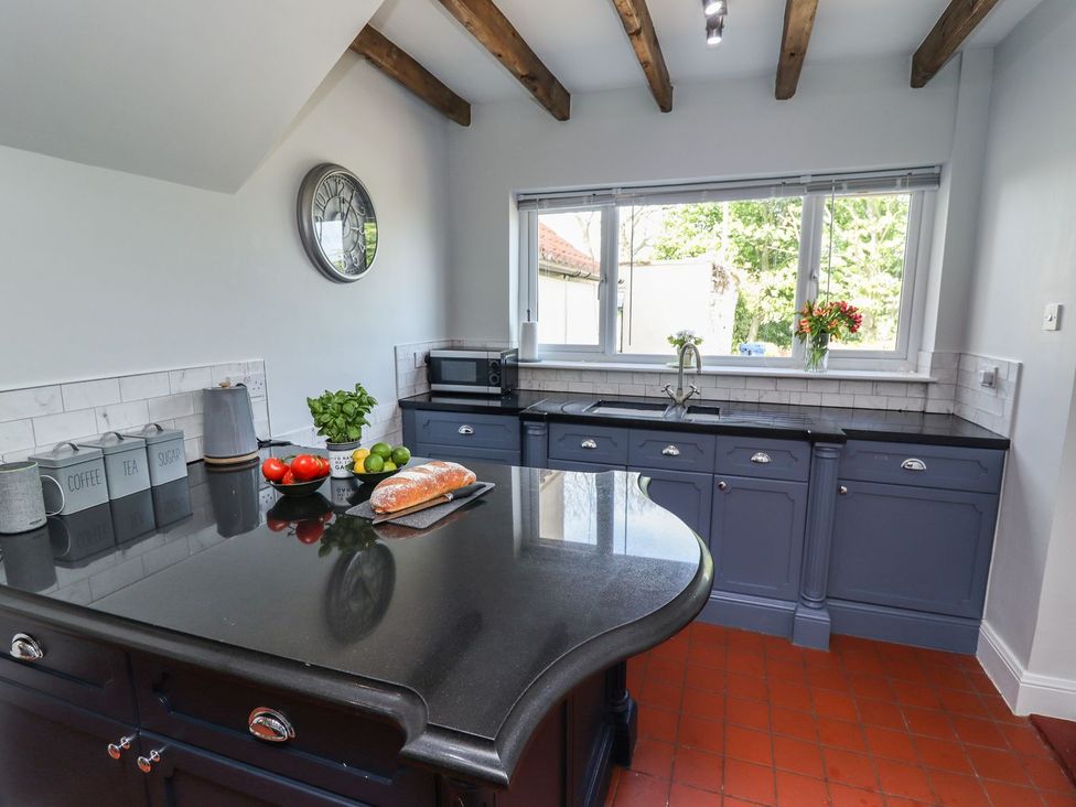 A kitchen with a sink and kitchen island at Reighton House in Filey