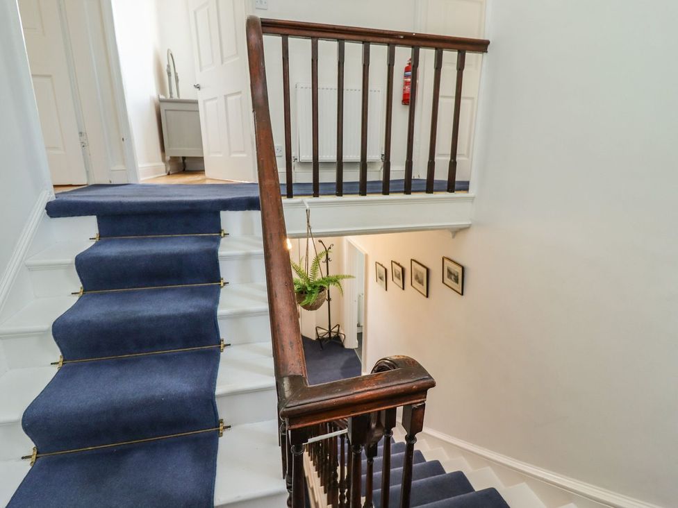A stairwell with a handrail and carpet at Reighton House in Filey