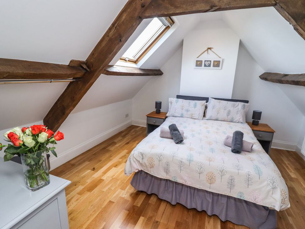A bedroom with a bed and floral arrangement at Reighton House in Filey