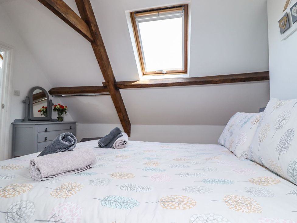 A bedroom with a bed and mirror at Reighton House in Filey