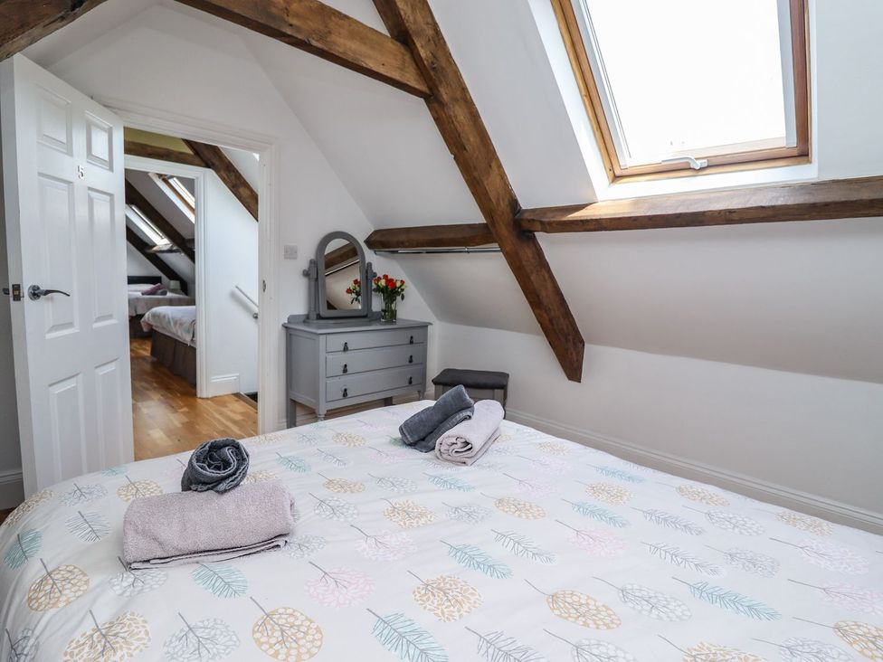 A bedroom with a bed and dresser at Reighton House, Filey