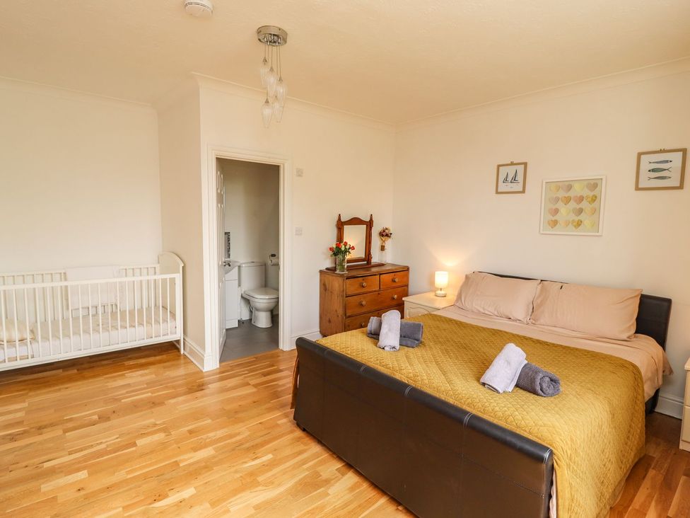 A bedroom with a bed and crib at Reighton House in Filey