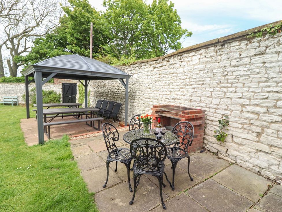 A garden area with a gazebo, table, and chairs at Reighton House in Filey