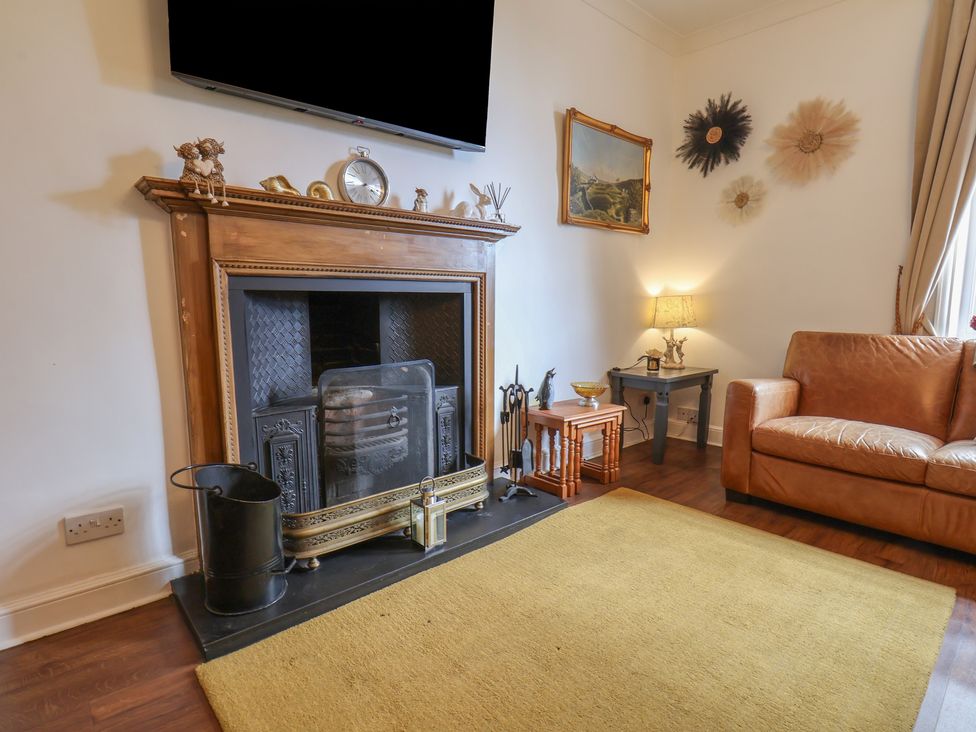 A living room with a fireplace and sofa at Reighton House in Reighton near Filey