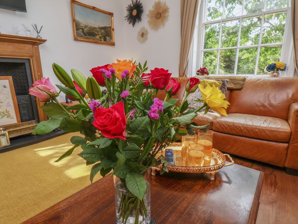 A living room with flowers on a table at Reighton House in Reighton near Filey