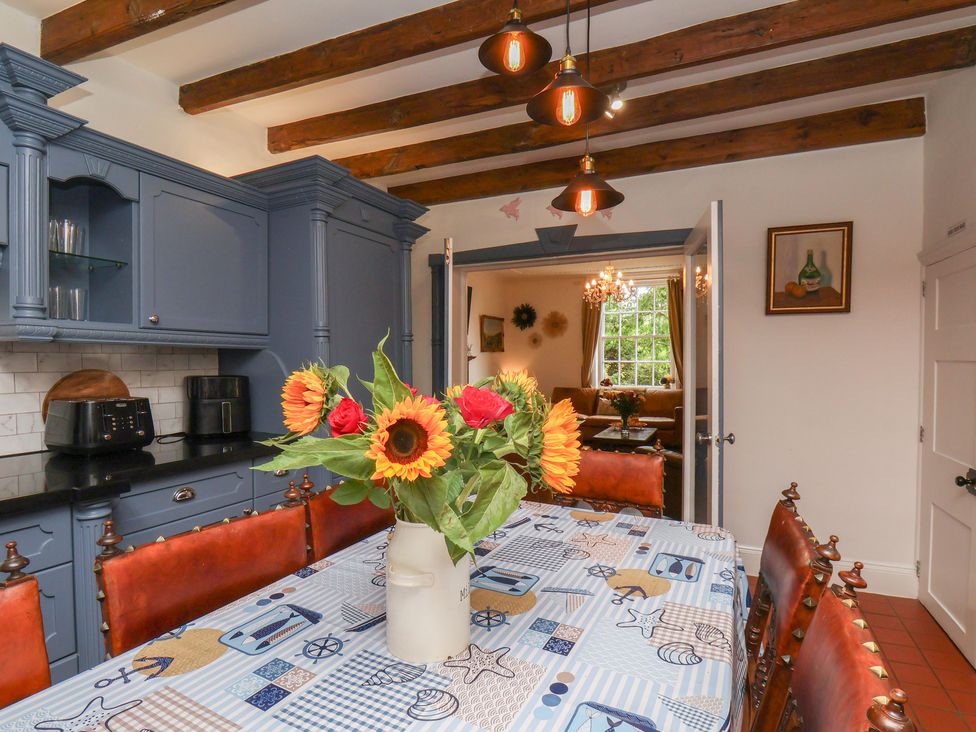 A kitchen with a dining table and flower vase at Reighton House in Reighton near Filey