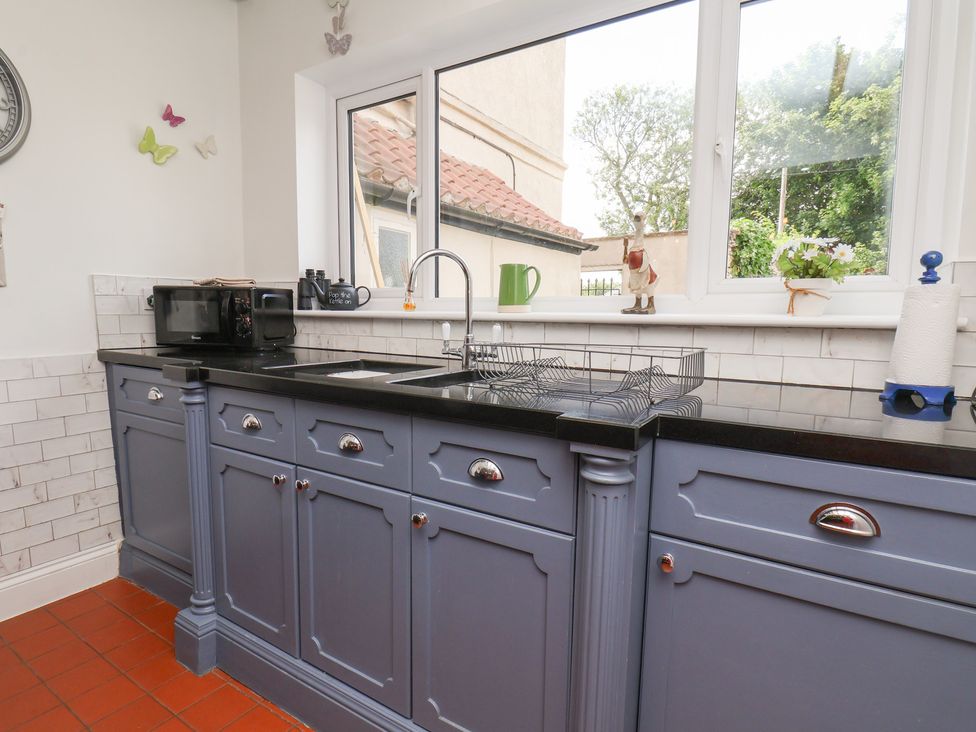A kitchen with a sink and cabinets at Reighton House in Reighton near Filey