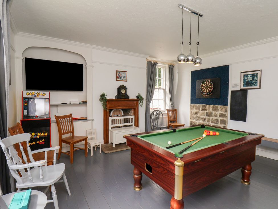 A game room with a pool table and arcade machine at Reighton House near Filey