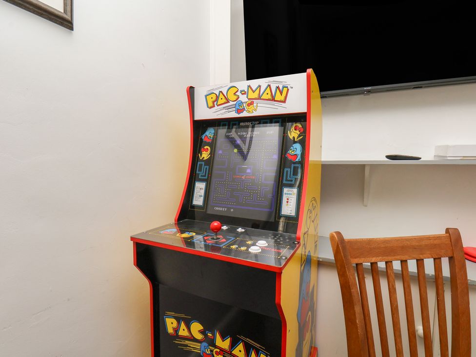 An arcade machine with a Pac-Man theme in a game room at Reighton House in Reighton near Filey
