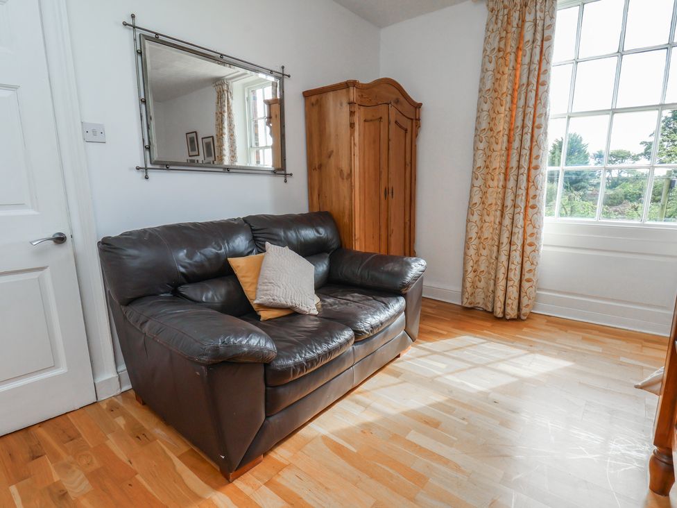 A living room with a sofa and wardrobe at Reighton House in Reighton near Filey