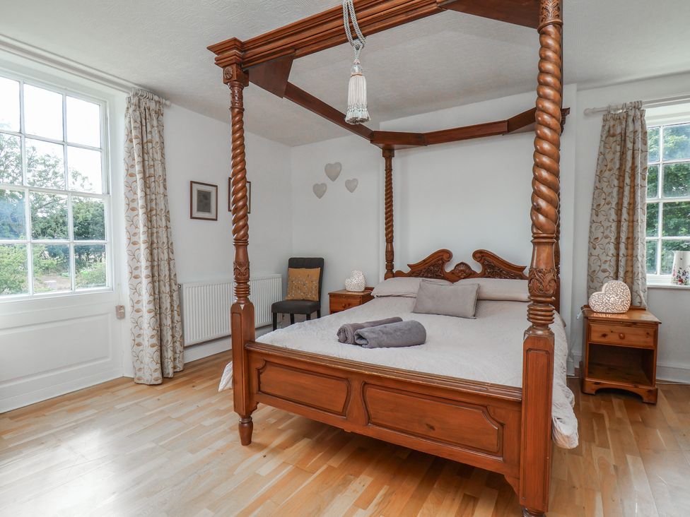 A bedroom with a four-poster bed and bedside tables at Reighton House in Reighton near Filey