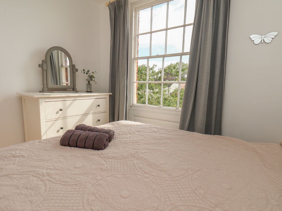 A bedroom with a bed and dresser at Reighton House in Reighton near Filey