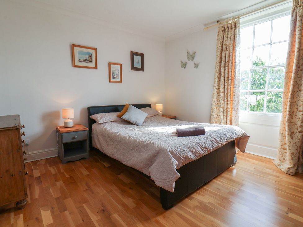 A bedroom with a bed and nightstand at Reighton House in Reighton near Filey