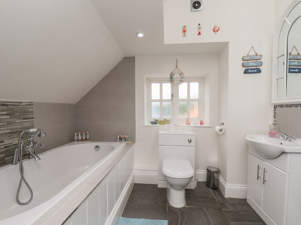 A bathroom with a bathtub and sink at Reighton House in Reighton near Filey