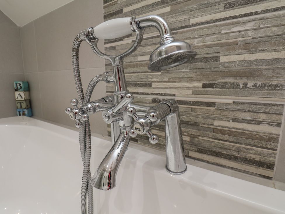 A bathtub with a chrome faucet and showerhead at Reighton House, Reighton near Filey