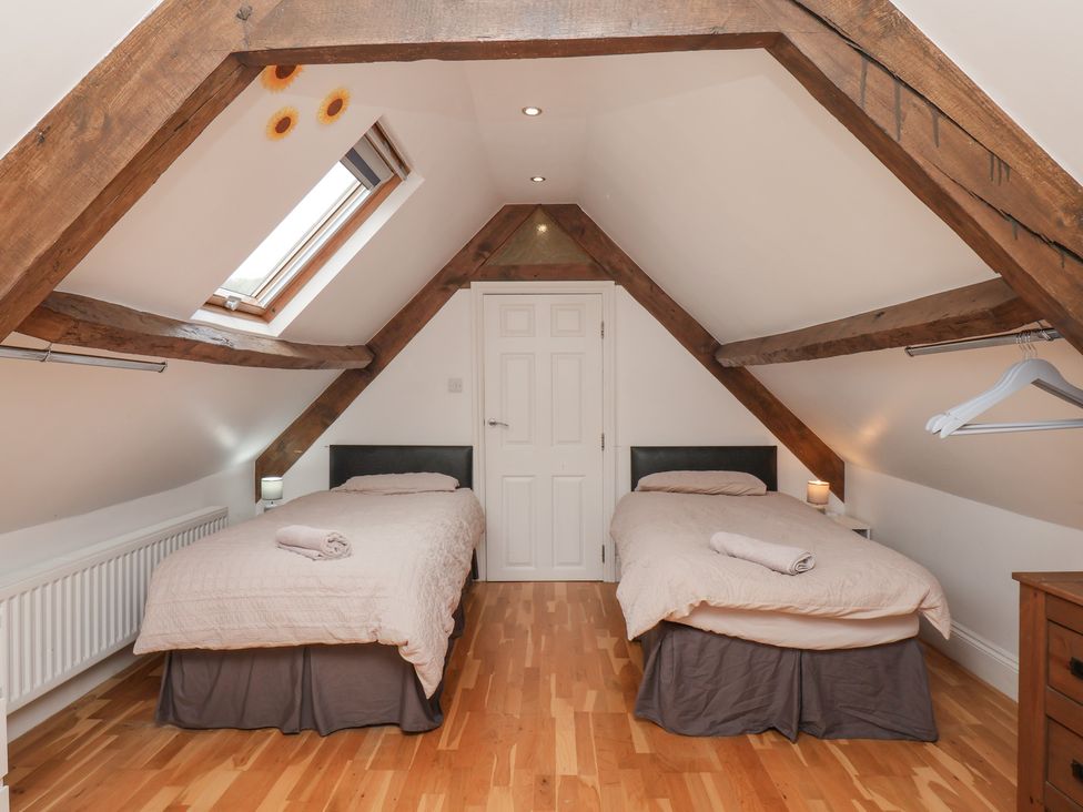A bedroom with two single beds and a skylight at Reighton House in Reighton near Filey