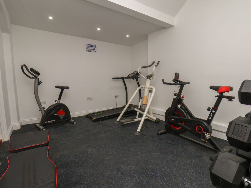 A gym with exercise equipment and mats at Reighton House in Reighton near Filey